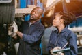 Auto garage worker Black African working together to fix service car vahicle wheel support together