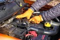 Auto maintenance concept. Hands off driver in orange rubber gloves checks car, open hood. Cars and transportation repairing, close