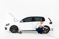 auto mechanic in blue uniform inflating tire and checking air with gauge pressure Royalty Free Stock Photo