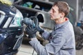 Auto mechanic buffing and polishing car headlight Royalty Free Stock Photo