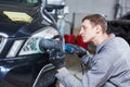 Auto mechanic buffing and polishing car headlight