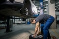 Mechanic adjusting tire wheel at repair garage Royalty Free Stock Photo