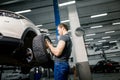 Mechanic adjusting tire wheel at repair garage Royalty Free Stock Photo