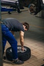 Mechanic adjusting tire wheel at repair garage Royalty Free Stock Photo