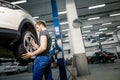 Mechanic adjusting tire wheel at repair garage Royalty Free Stock Photo