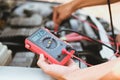 auto mechanic check car battery voltage by voltmeter multimeter
