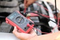 auto mechanic check car battery voltage by voltmeter multimeter Royalty Free Stock Photo