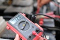 auto mechanic check car battery voltage by voltmeter multimeter Royalty Free Stock Photo