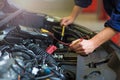 Auto mechanic checking car battery voltage Royalty Free Stock Photo
