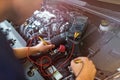 Auto mechanic checking car battery voltage