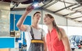 Auto mechanic checking the disk brake rotors of the car of a fem