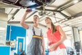 Auto mechanic checking the disk brake rotors of the car of a female customer