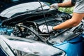 Auto mechanic checking the oil level in car engine. Royalty Free Stock Photo