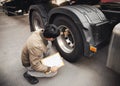 Auto Mechanic is Checking the Truck`s Safety Maintenance Checklist. Fixing. Inspection Safety of Semi Truck Wheels Tires Royalty Free Stock Photo