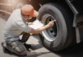 Auto Mechanic is Checking the Truck`s Safety Maintenance Checklist. Inspection Safety of Semi Truck Wheels Tires. Repair Shop. Royalty Free Stock Photo