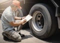 Auto Mechanic is Checking the Truck`s Safety Maintenance Checklist. Inspection Safety of Semi Truck Wheels Tires. Repair Shop. Royalty Free Stock Photo