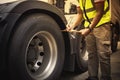 Auto Mechanic is Checking the Truck`s Safety Maintenance Checklist. Inspection Safety of Semi Truck Wheels Tires Royalty Free Stock Photo