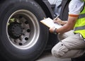 Auto Mechanic is Checking the Truck`s Safety Maintenance Checklist. Lorry Fixing. Truck Inspection Safety of Semi Truck Wheels. Royalty Free Stock Photo