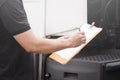 Auto Mechanic Driver Holding Clipboard Daily Checking Maintenance and Safety Program of Semi Truck. Royalty Free Stock Photo