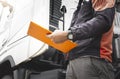 Auto Mechanic Driver Holding Clipboard is Checking Maintenance and Safety Program of Semi Truck. Royalty Free Stock Photo