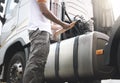 Auto Mechanic Driver Holding Clipboard is Checking Semi Truck Fuel Tank. Inspection, Maintenance and Safety Driving. Royalty Free Stock Photo