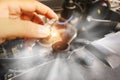 Auto mechanic hand opens the radiator cap with steam escaping around the engine compartment from the high heat Royalty Free Stock Photo