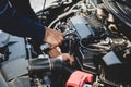 Auto mechanic hands using wrench to repair a car engine.