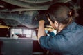 Auto mechanic handsome worker man checking wheel tires at garage, car service technician repairing customer car vehicle, Royalty Free Stock Photo