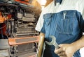 Auto mechanic holding wrench checking and repair a truck engine Royalty Free Stock Photo