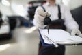 Auto mechanic holds clipboard and car keys