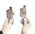 An auto mechanic holds in his hands old worn out brake pads on a white background, isolate. The concept of replacing brake pads Royalty Free Stock Photo
