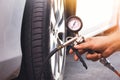 A auto mechanic inflates a tire with an air tire inflating gun