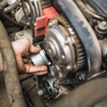 An auto mechanic installs a timing belt idler Royalty Free Stock Photo