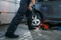 Auto mechanic jacks the car in tire service