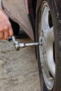 Auto mechanic man with electric screwdriver changing tire outside. Car service. Hands replace tires on wheels. Tire installation Royalty Free Stock Photo