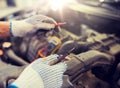 Auto mechanic man with multimeter testing battery Royalty Free Stock Photo