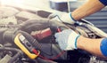 Auto mechanic man with multimeter testing battery Royalty Free Stock Photo