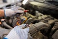 Auto mechanic man with multimeter testing battery Royalty Free Stock Photo