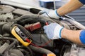Auto mechanic man with multimeter testing battery Royalty Free Stock Photo