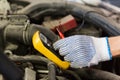 Auto mechanic man with multimeter testing battery Royalty Free Stock Photo