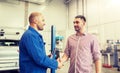 Auto mechanic and man shaking hands at car shop Royalty Free Stock Photo