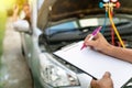 Auto mechanic perform vehicle checkup while service advisor take notes,Professional