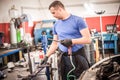 Auto mechanic repairer changing spark plugs on the car