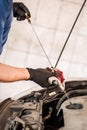 Auto mechanic repairer checking level of oil in car engine