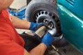 Auto mechanic repairing car wheel disk. Royalty Free Stock Photo