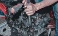 Auto mechanic repairing the engine of a car with different tools Royalty Free Stock Photo