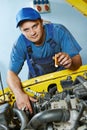 Auto mechanic repairman at work with car engine