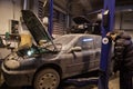 Auto mechanic repairs a car in a garage.