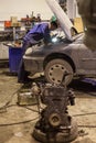 Auto mechanic repairs a car in a garage.