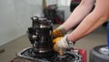 Auto mechanic repairs manual transmission, fixes gearbox fork in service station. Wearing gloves, technician restores